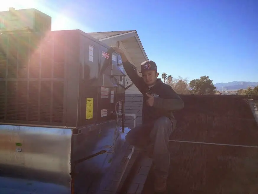 HVAC technician performing HVAC Inspection on a rooftop unit in Orono